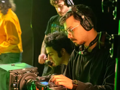 Crew configuring camera on green screen set